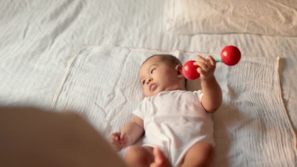 Baby Holds Toy While Lies Bed High Quality Footage — Stockvideo