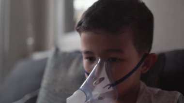 Astım spreyinden buhar soluyan bir çocuk. Akciğer hastalıklarının tedavisi. Yüksek kalite 4k görüntü