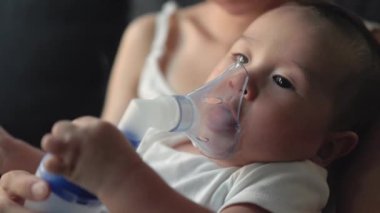 Close up view of baby breathing an inhaler. High quality 4k footage