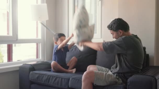 Young Father Little Son Enjoy Pillow Fighting Sit Sofa Home — Stock Video