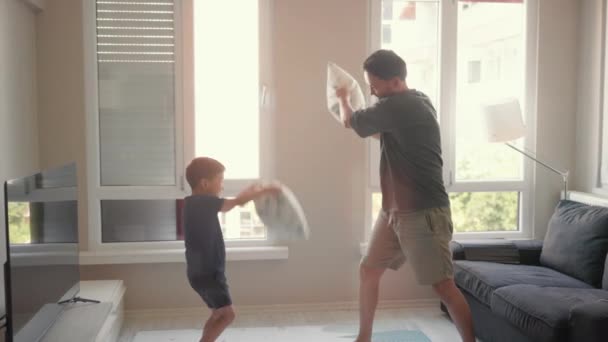 Young Father Little Son Enjoy Pillow Fighting Sit Sofa Home — Vídeos de Stock