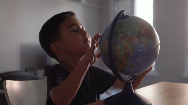 Cute Preschooler explores countries on the globe. High quality 4k footage