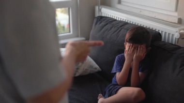 Little boy closes his face and crying while mother scolds him. High quality 4k footage