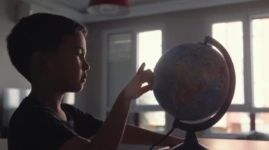 Cute Preschooler explores countries on the globe. High quality 4k footage