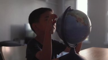 Cute Preschooler explores countries on the globe. High quality 4k footage