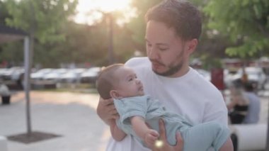 Happy father is holding cute baby and kisses while he is laughing. High quality 4k footage