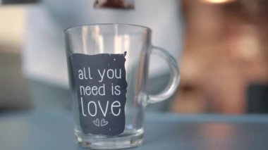 Close up view of woman brews tea in glass cup. High quality 4k footage