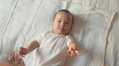 Top view of Mother stroking her baby. baby lying on bed. High quality 4k footage