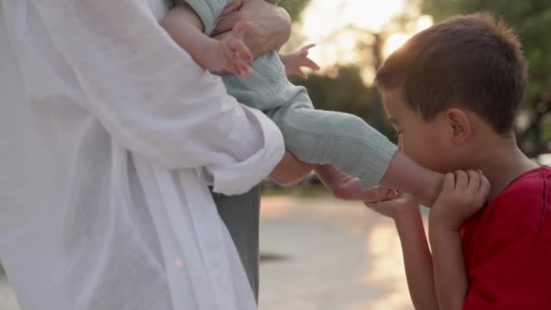 Happy Cute Preschooler Kissing His Baby Brothers Feet Mothers Hand — Vídeo de Stock