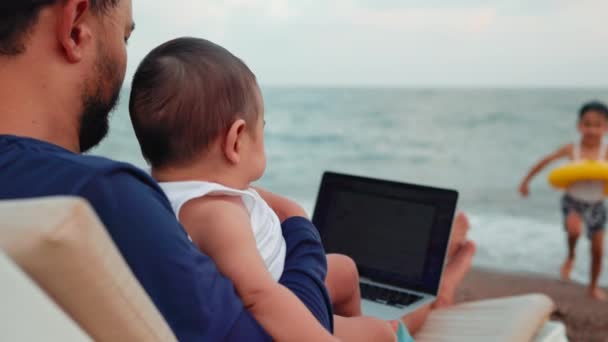 Фрилансер Работающий Ноутбуке Присматривающий Детьми Концепция Удаленной Работы Работа Отпуске — стоковое видео