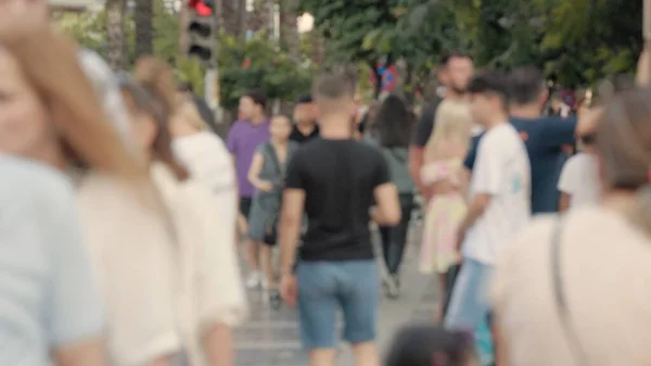 Lens blur, out of focus. a crowd of pedestrians are walking along the street. High quality 4k footage