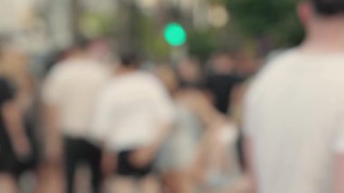 Lens blur, out of focus. a crowd of pedestrians are walking along the street. High quality 4k footage