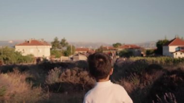 Rear view of kid is running through lavender fields . High quality 4k footage