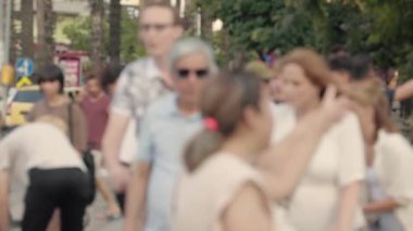 Lens blur, out of focus. a crowd of pedestrians are walking along the street. High quality 4k footage