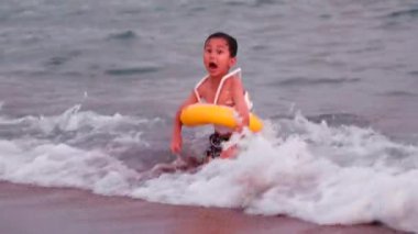 Happy Little child with swimming circle swims on the sea. Boy has fun on waves. High quality 4k footage