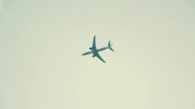 Airplane flies into clouds on grey sky. High quality 4k footage