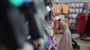 Woman looking for a flip-flops in supermarket. High quality 4k footage