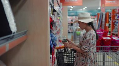 Woman looking for a flip-flops in supermarket. High quality 4k footage