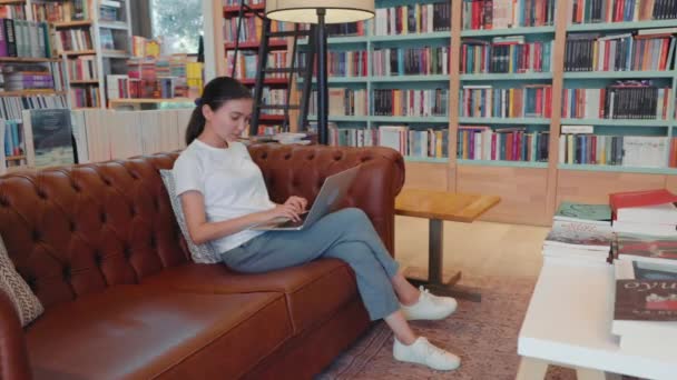 Young Woman Texting Laptop Sitting Sofa Library Office Home High — Stockvideo