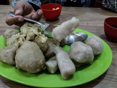 Yeşil tabakta cuko soslu Pempek veya empek-empek. Pempek, mpek-mpek veya ampek-empek, balık ve tapyokadan yapılır, bu yemek çok lezzetlidir ve Palembang, Güney Sumatra, Endonezya 'dan gelir..