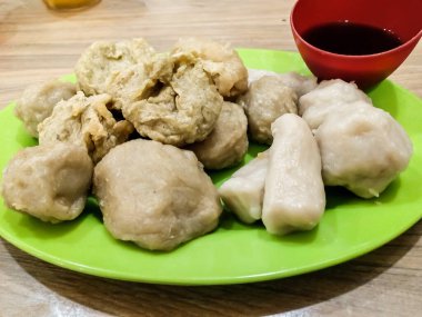 Yeşil tabakta cuko soslu Pempek veya empek-empek. Pempek, mpek-mpek veya ampek-empek, balık ve tapyokadan yapılır, bu yemek çok lezzetlidir ve Palembang, Güney Sumatra, Endonezya 'dan gelir..