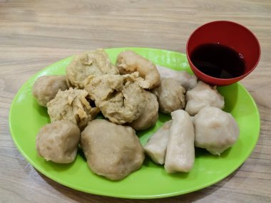 Yeşil tabakta cuko soslu Pempek veya empek-empek. Pempek, mpek-mpek veya ampek-empek, balık ve tapyokadan yapılır, bu yemek çok lezzetlidir ve Palembang, Güney Sumatra, Endonezya 'dan gelir..