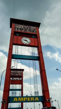Palembang, Endonezya - 25 Şubat 2022 - Ampera Köprüsü (Ampera Köprüsü) Güney Sumatra 'da Palembang şehrinin bir ikonudur. Bulutlu arkaplanı olan ampera fotoğrafı