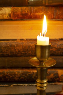 Masadaki eski kitaplar, mum ışığında okumak, büyüteç.