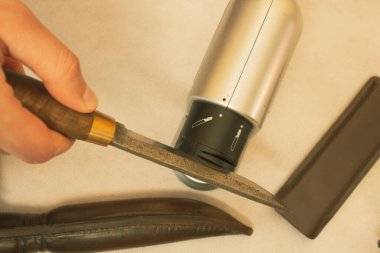 Elektrikli öğütücüyle antika bir bıçağı bilemek, yüksek karbonlu çelik.