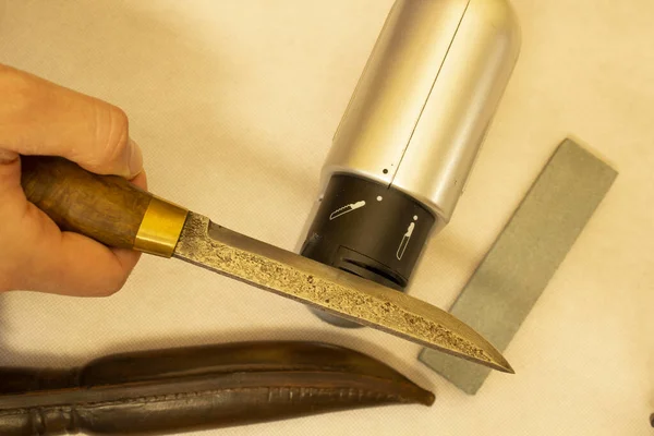 sharpening an antique knife with an electric grinder, high carbon steel