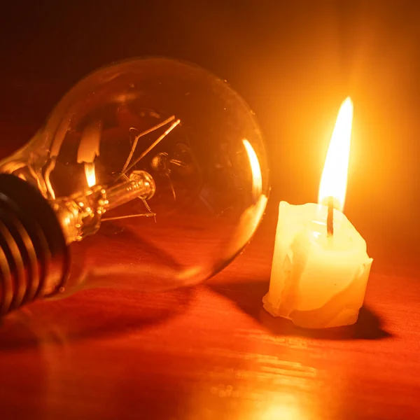 light bulb and candle on black background