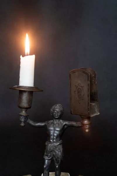 sculpture of a woman holding a candle, a candlestick. burning candle