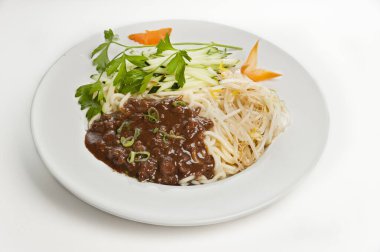 Soslu erişte tabağı, tipik Çin mutfağı, beyaz arka planda izole edilmiş yemek.