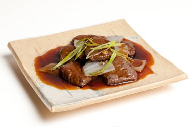 Beyaz arka planda izole edilmiş tabaklarda sunulan soslu et