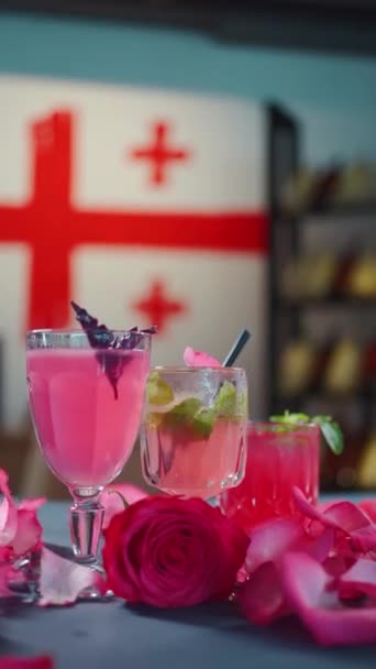 Cocktail rose et boisson de limonade en verre et pétales de rose tombant sur la table — Video