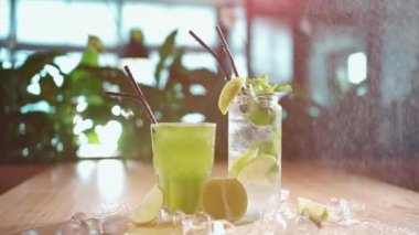 Mojito 'ya nane ve limon sıkarak cam ve kafede yeşil tarkhun içeceği sıkmak.