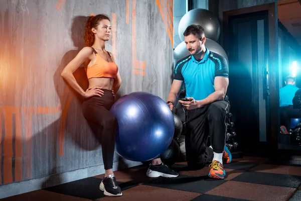 Joven hembra tiene entrenamiento y ejercicio con la pelota en forma y gimnasio entrenador personal — Foto de Stock