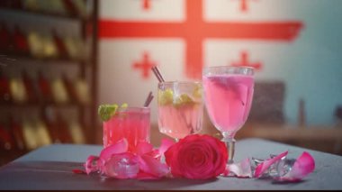 Pembe limonata içeceğine su püskürtmek ve gül yapraklarıyla bardakta kokteyl yapmak.