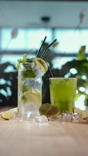 Disemprotkan pada mojito dengan mint dan kapur dalam gelas dan hijau tarkhun minum di kafe — Stok Video