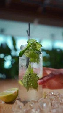 Kadın eli ve taze mojito. Kafede naneli ve limonlu kahve.