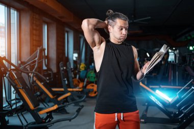 Spor salonunda özel antrenörlük ya da kitap eğitimi alan bir öğrenci.