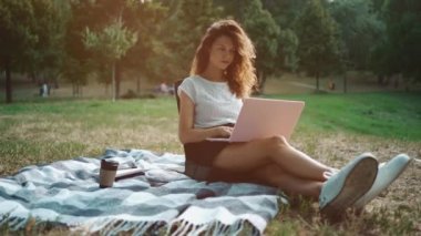 Çekici kız serbest yazar dışarıda, parkta dizüstü bilgisayarla çalışmaya başladı.