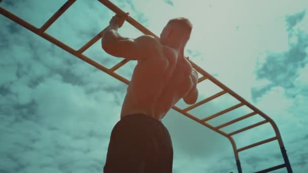 Culturista atleta uomo con busto perfetto tirare su all'aperto in tempo soleggiato — Video Stock