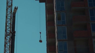 Yeni modern gökdelen inşaatının tuğlalarını kaldırır ya da şehirde yaşayan bir bina