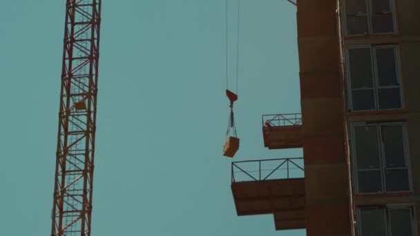 Lifting bricks construction of new modern skyscraper or living building in city — Stock Video