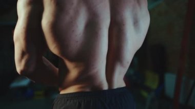 Vücut geliştiren çekici bir erkek. Vücut yapısı mükemmel. Spor salonunda kaslı vücut pozu veriyor.
