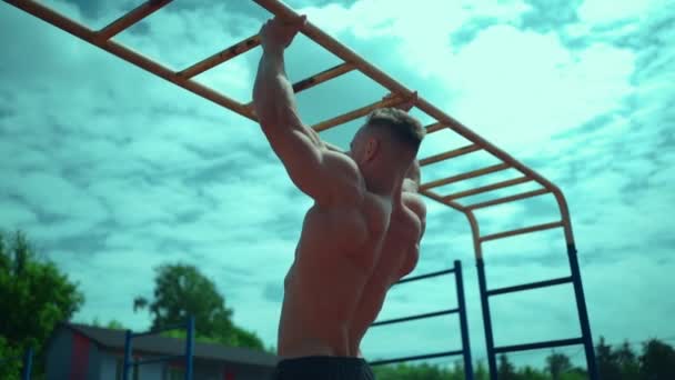 Culturista atleta hombre con torso perfecto tire hacia arriba al aire libre en tiempo soleado — Vídeos de Stock