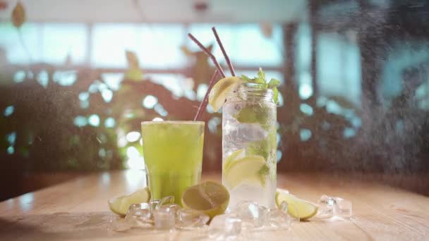 Besprutning på mojito med mynta och lime i glas och grön tarkhun dryck på café — Stockvideo