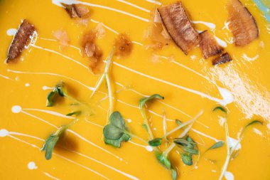 Taze sarı balkabağı kremalı çorba, domuz pastırması ve yeşil bezelye