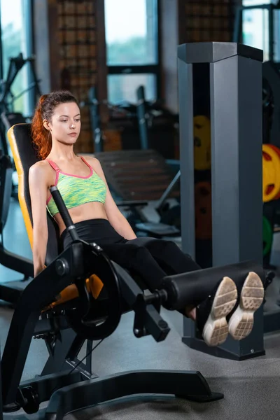 Gyönyörű nő van láb edzés és gyakorló gép fitness edzőteremben — Stock Fotó